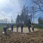 Helfer bei der Pflege einer Grünfläche auf einem Spielplatz
