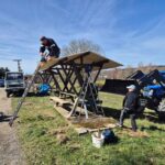 Arbeitseinsatz an einem überdachten Spielplatzbereich mit Holzkonstruktion