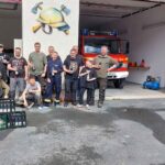 Helfergruppe vor einem Feuerwehrfahrzeug bei der Spielplatzaktion 2026