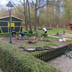 Spielplatzbereich mit Spielgeräten und Grünanlagen